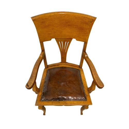 937 - An Edwardian oak high back armchair with original leather seat.