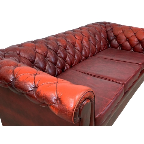 946 - An ox-blood leather button back 3 seater sofa. 191cm.