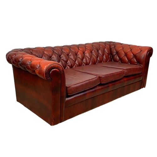 946 - An ox-blood leather button back 3 seater sofa. 191cm.