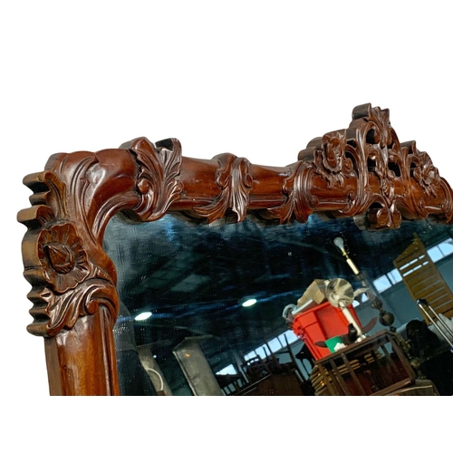 329 - A large ornate mahogany framed mirror. 142 x 87cm