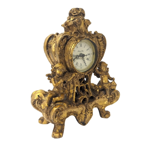 354 - An ornate gilt mantle clock with Royal Doulton and Royal Worcester plates. Clock 18x23.5cm