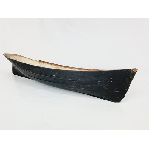 87 - A 19th century carved wooden model of a ship in early construction. 61cm