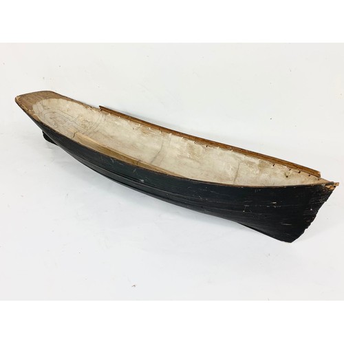 87 - A 19th century carved wooden model of a ship in early construction. 61cm