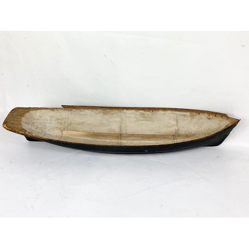 87 - A 19th century carved wooden model of a ship in early construction. 61cm