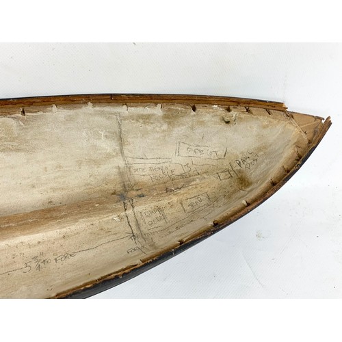 87 - A 19th century carved wooden model of a ship in early construction. 61cm