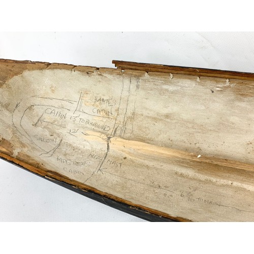 87 - A 19th century carved wooden model of a ship in early construction. 61cm