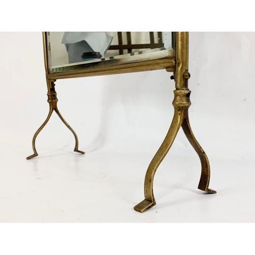 91 - An Edwardian brass bevelled mirror fire screen. 68cm