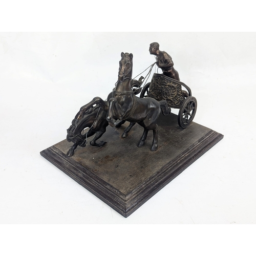 99 - An early 20th century spelter chariot figure on a wooden base. 33x25x25cm