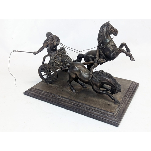 99 - An early 20th century spelter chariot figure on a wooden base. 33x25x25cm