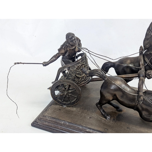 99 - An early 20th century spelter chariot figure on a wooden base. 33x25x25cm