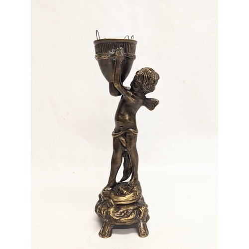 136 - A vintage bronze cherub candle holder. 24cm