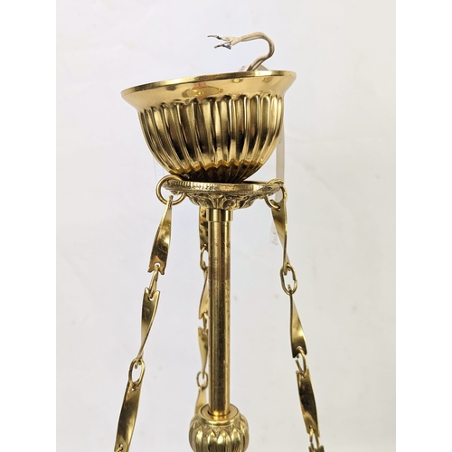 164 - An ornate brass light fitting with a glass shade. 20x50cm