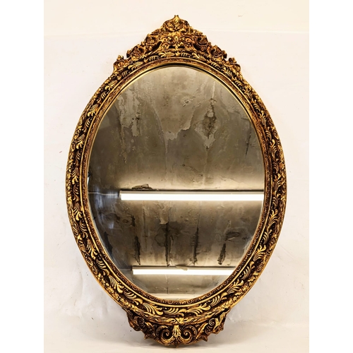 189 - A large ornate gilt framed oval mirror. 56x93cm