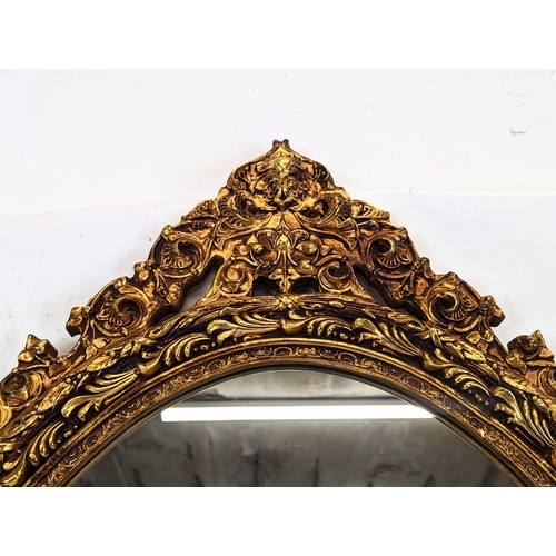 189 - A large ornate gilt framed oval mirror. 56x93cm