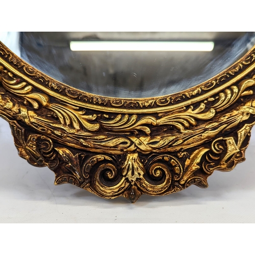 189 - A large ornate gilt framed oval mirror. 56x93cm