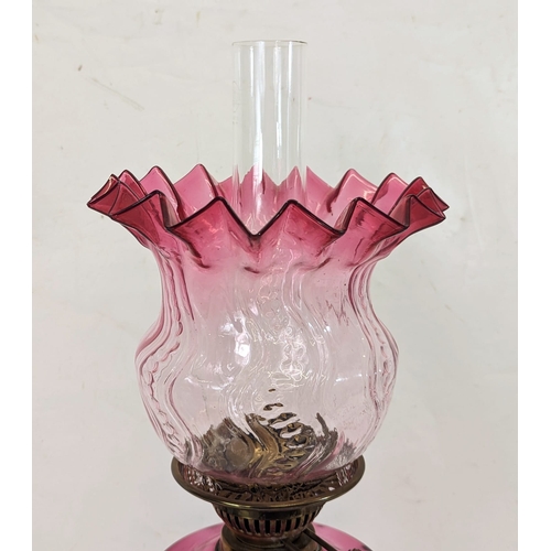 204 - A large Edwardian ruby glass brass oil lamp. With shade and funnel, 69cm