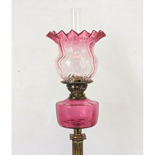 204 - A large Edwardian ruby glass brass oil lamp. With shade and funnel, 69cm