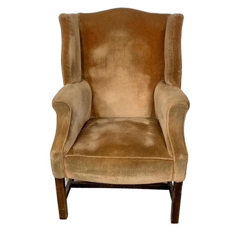 1129 - A vintage Georgian style wingback armchair.