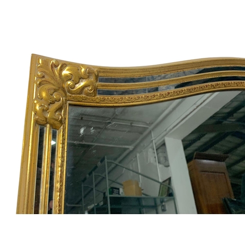 384 - A large ornate gilt framed mirror. 130 x 89.5cm