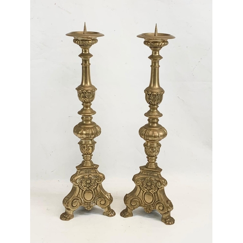 118 - A pair of large ornate brass church candlesticks. 65cm