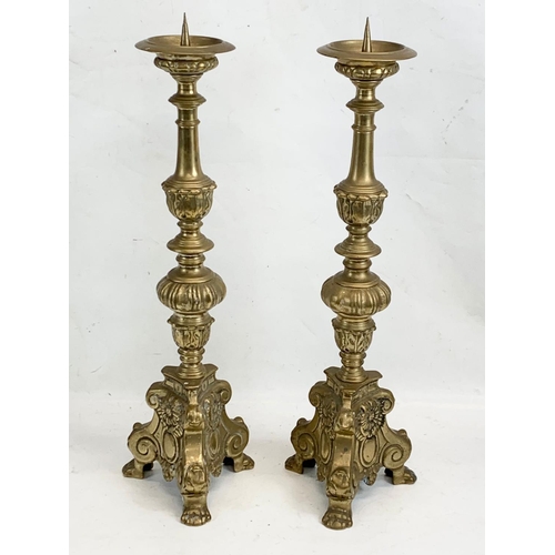 118 - A pair of large ornate brass church candlesticks. 65cm