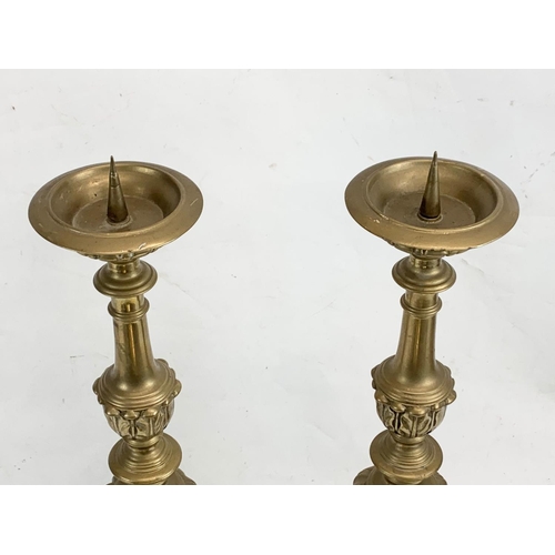 118 - A pair of large ornate brass church candlesticks. 65cm