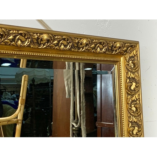 273 - A large ornate gilt framed mirror. 131 x 106cm