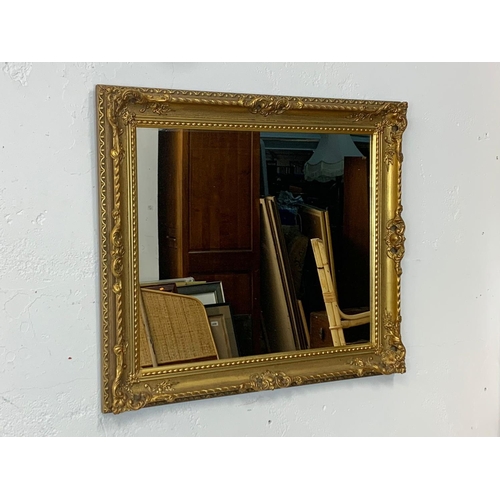 275 - An ornate gilt framed mirror. 75 x 66cm