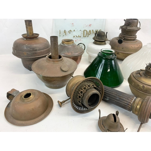 280 - A quantity of Victorian and early 20th century oil lamp parts and glass shades etc.