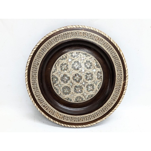 774 - A wooden Mother of Pearl inlaid plaque. 25cm