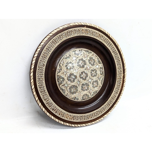 774 - A wooden Mother of Pearl inlaid plaque. 25cm