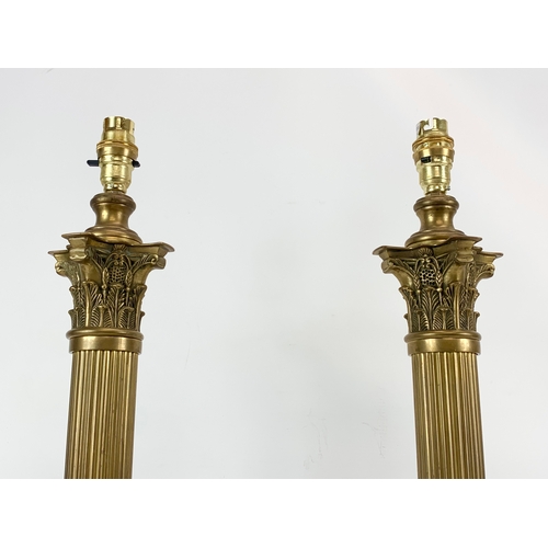 86 - A pair of large brass table lamps with Corinthian style pillars. 58cm.