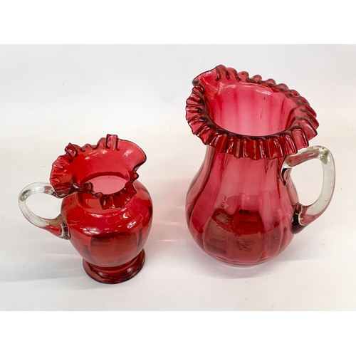 449 - 2 Victorian Ruby Glass jugs. Largest 18 x 22cm