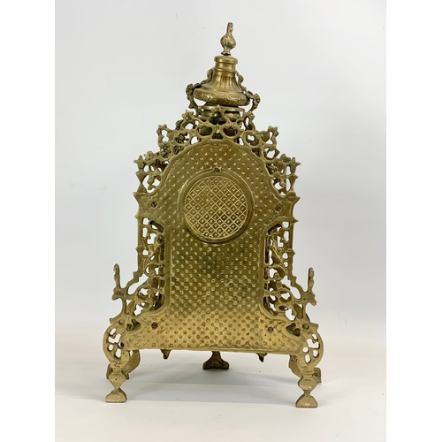 111 - A large 18th century style heavy brass clock set. Clock and a pair of candelabras. Clock measures 32... 