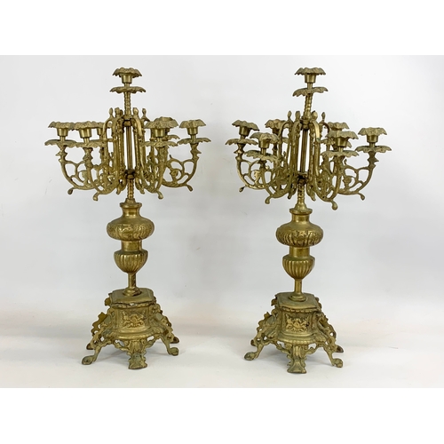 111 - A large 18th century style heavy brass clock set. Clock and a pair of candelabras. Clock measures 32... 