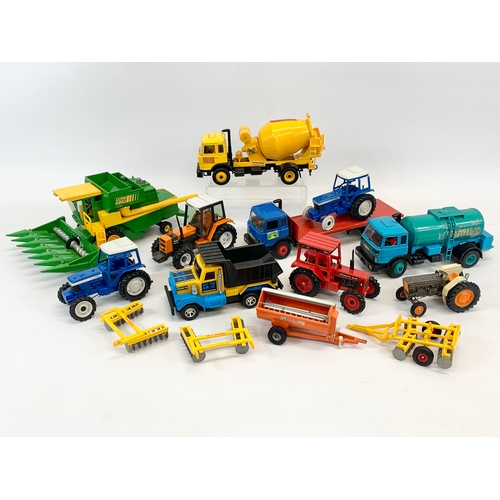 153 - A collection of Britains LTD model trucks and tractors etc. Including a Corn King Combine Harvester