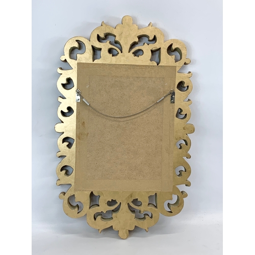 173 - An ornate 18th century style mirror. Plastic frame. 41 x 68cm