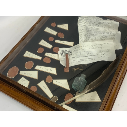 182 - A shadow box case with imitation seals etc. John Hancock. 45 x 57.5cm.