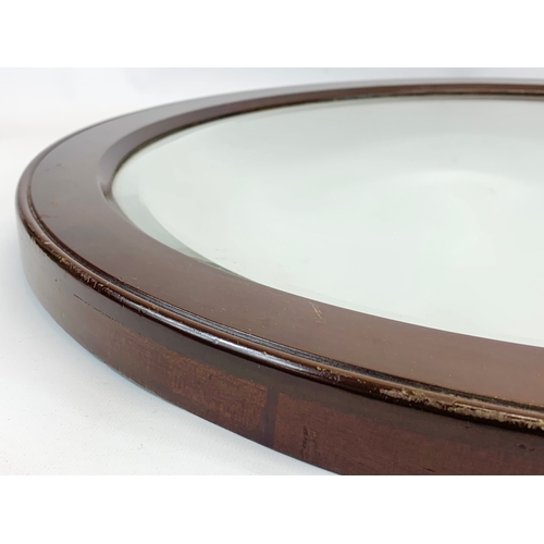 227 - An early 20th century mahogany framed oval mirror. Circa 1900-1920. 59.5cm