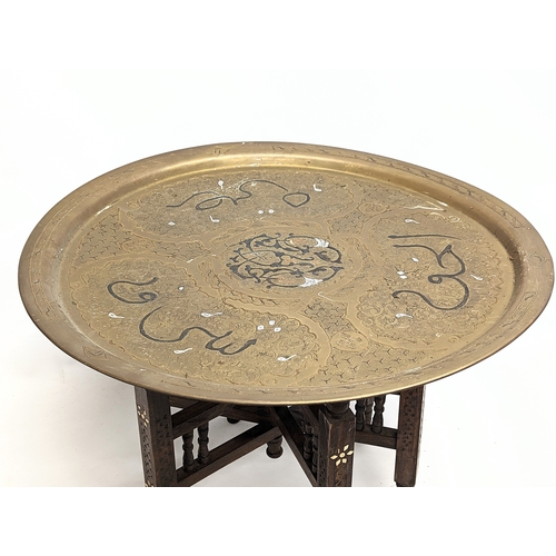 262 - An early 20th century Indian brass top folding table. Top measures 63.5cm