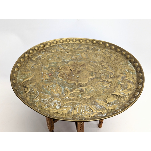 263 - An early 20th century Indian brass top folding table. Top measures 54.5cm