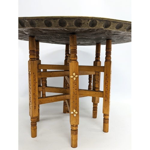 263 - An early 20th century Indian brass top folding table. Top measures 54.5cm