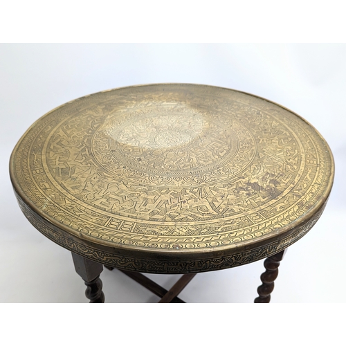 263A - An early 20th century folding brass top table. Top measures 59.5cm.