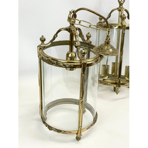 299 - A set of 3 matching ornate brass light fittings with glass panels. 20 x 58cm including chain.