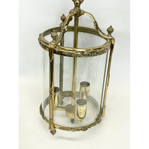 299 - A set of 3 matching ornate brass light fittings with glass panels. 20 x 58cm including chain.