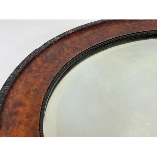 317 - An Edwardian oval mirror. 71 x 56cm