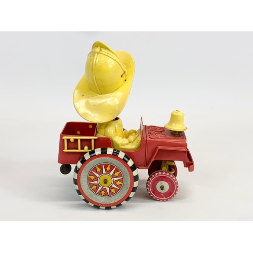 52 - A vintage windup tin plate Fireman in truck. 14 x 17cm.