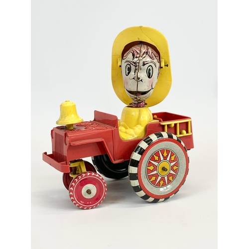 52 - A vintage windup tin plate Fireman in truck. 14 x 17cm.