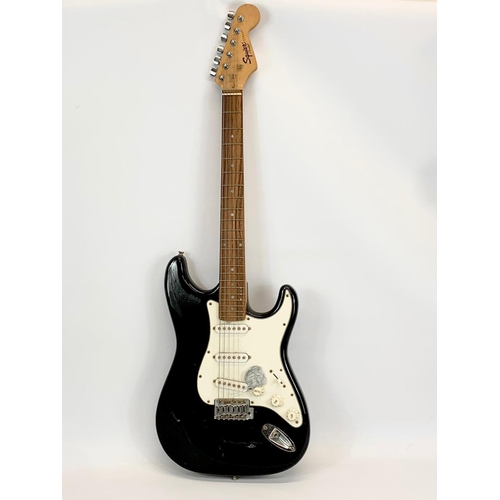 68 - An electric guitar by Fender. Squier Strat. 99cm