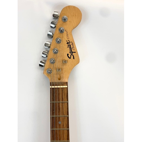 68 - An electric guitar by Fender. Squier Strat. 99cm